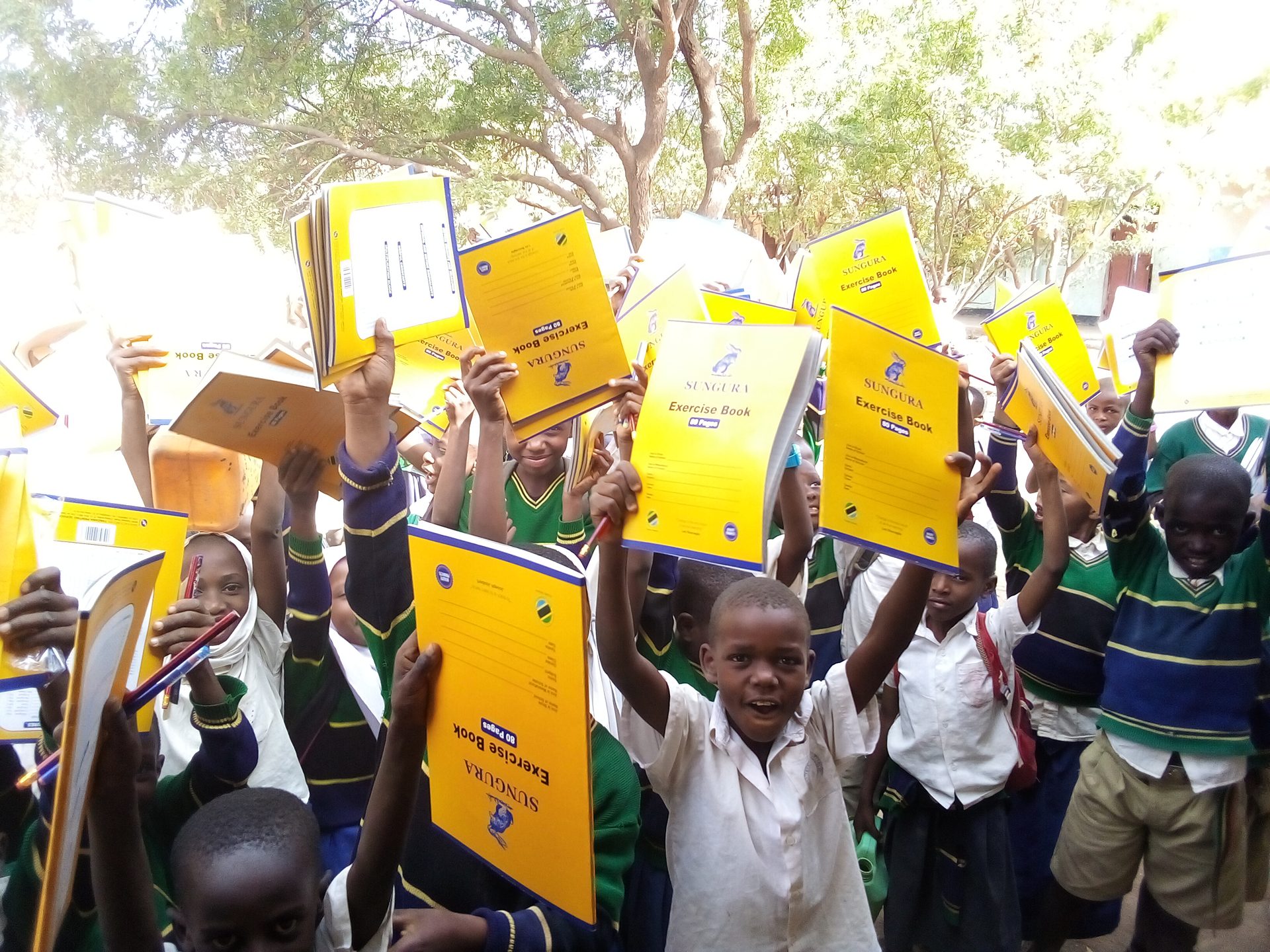 Tanzanian schoolchildren holding up new exercise books
