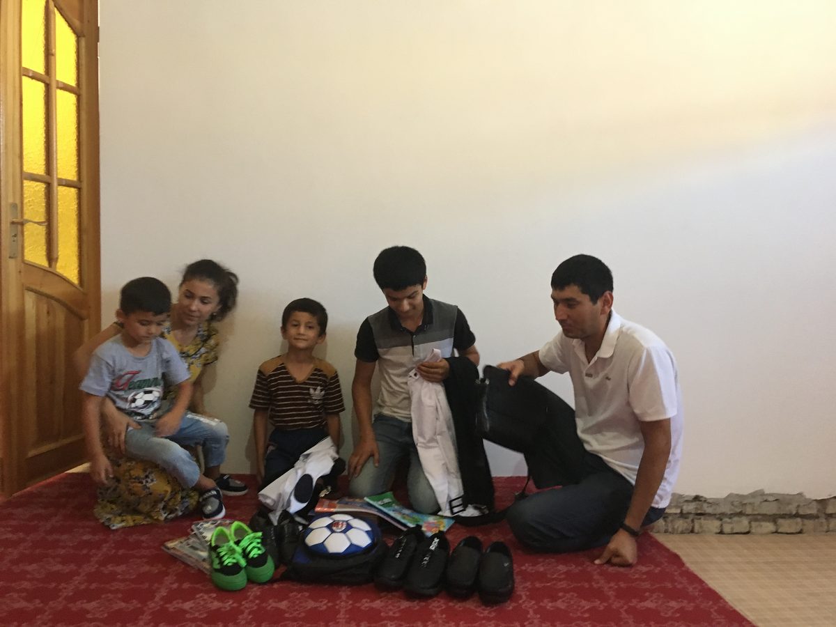 Family in Khiva receiving school supplies